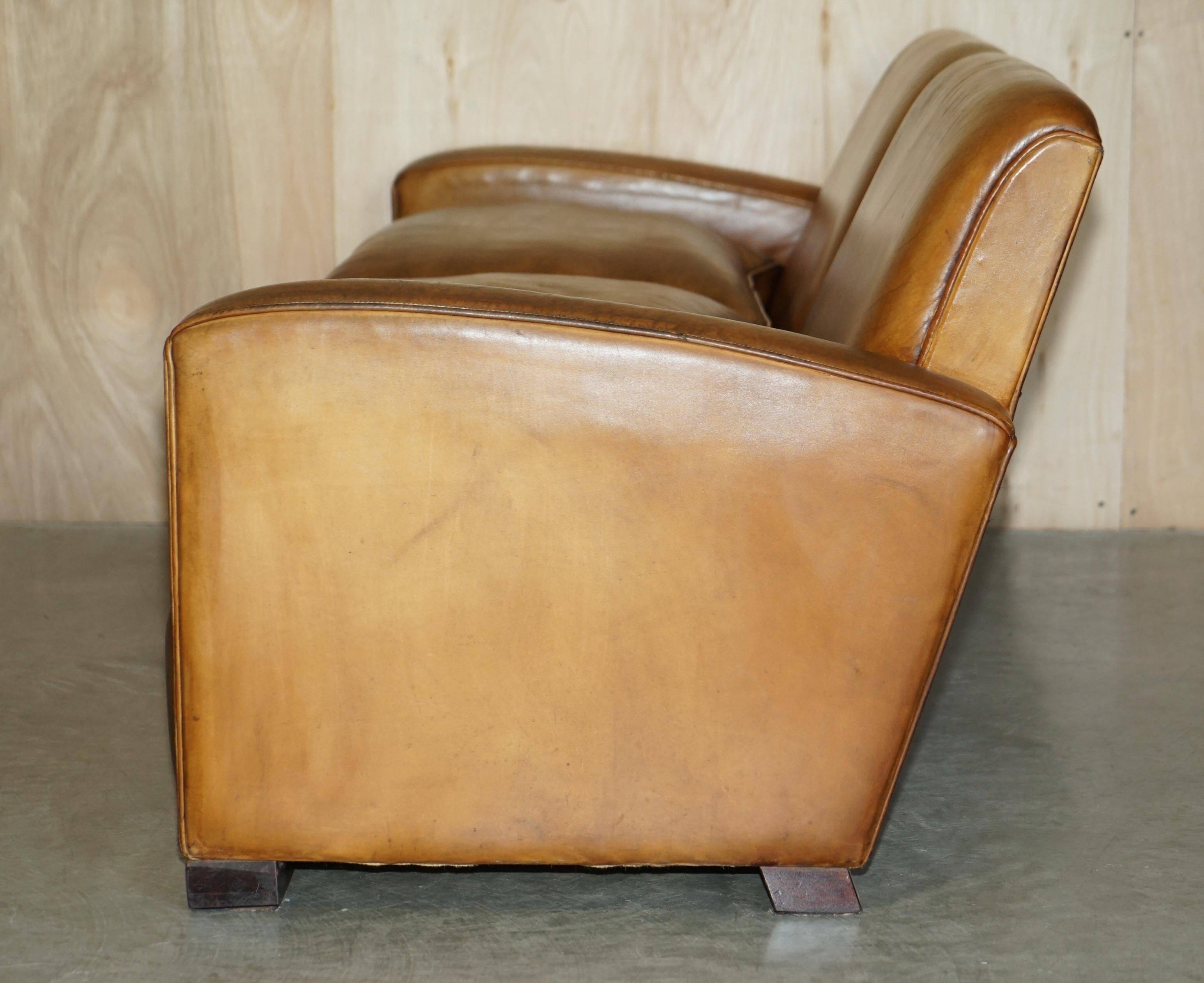 Three-seater Art Deco style leather sofa with feather cushions.