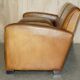 Three-seater Art Deco style leather sofa with feather cushions.