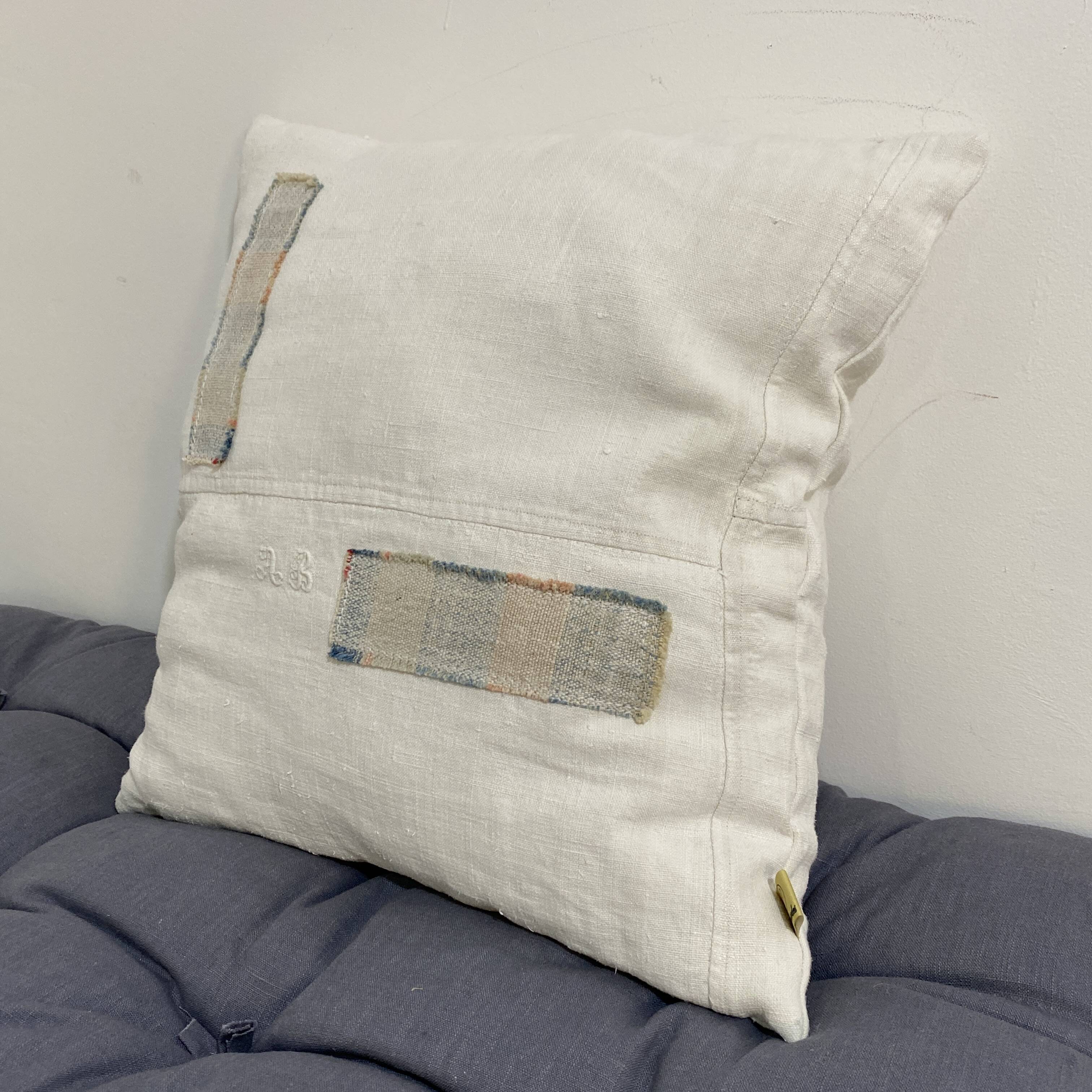 Coussin carré en toile ancienne style kilim tissé, patché, monogramme AB