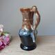 Vintage 1960s brown and blue flame-patterned stoneware wine jug carafe.
