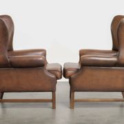 Ensemble de 2 fauteuils à oreilles en cuir de vache de style anglais.
