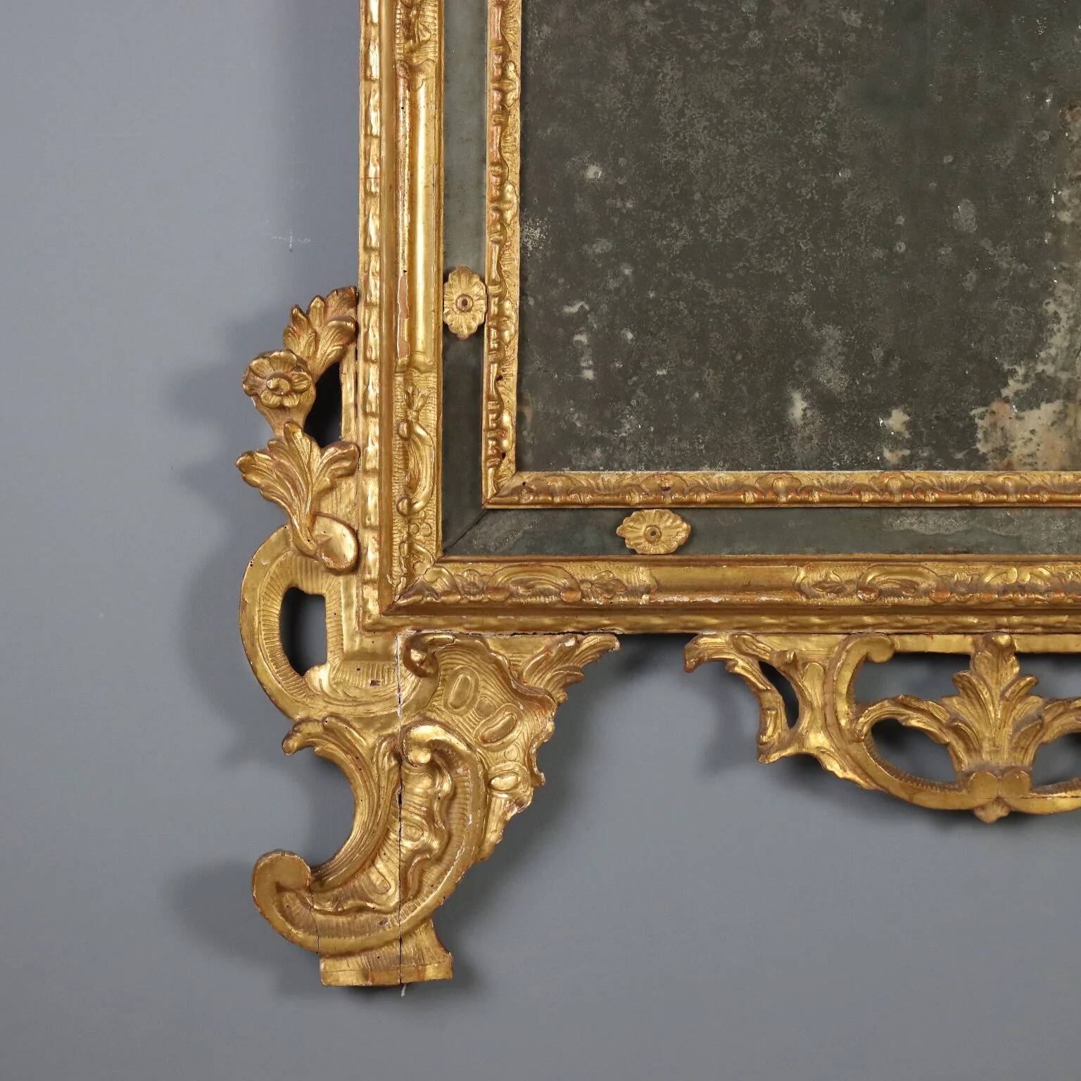 Antique gilded wooden mirror with rococo patterns, Italy, 18th century.