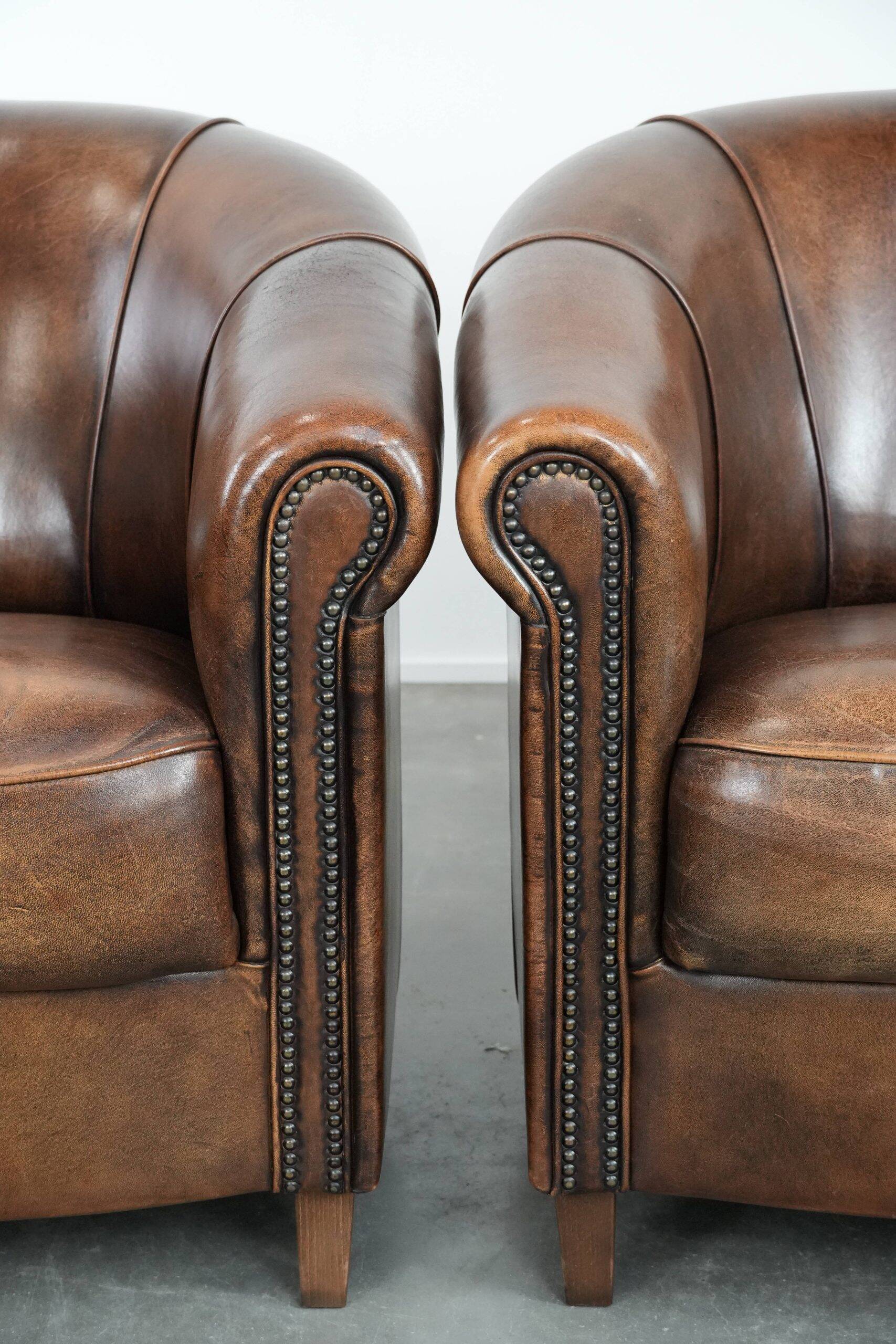 Set of two sheepskin club armchairs with fixed seat cushions