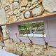 Coat rack or wall-mounted entrance wardrobe with scroll arms and antique hooks.