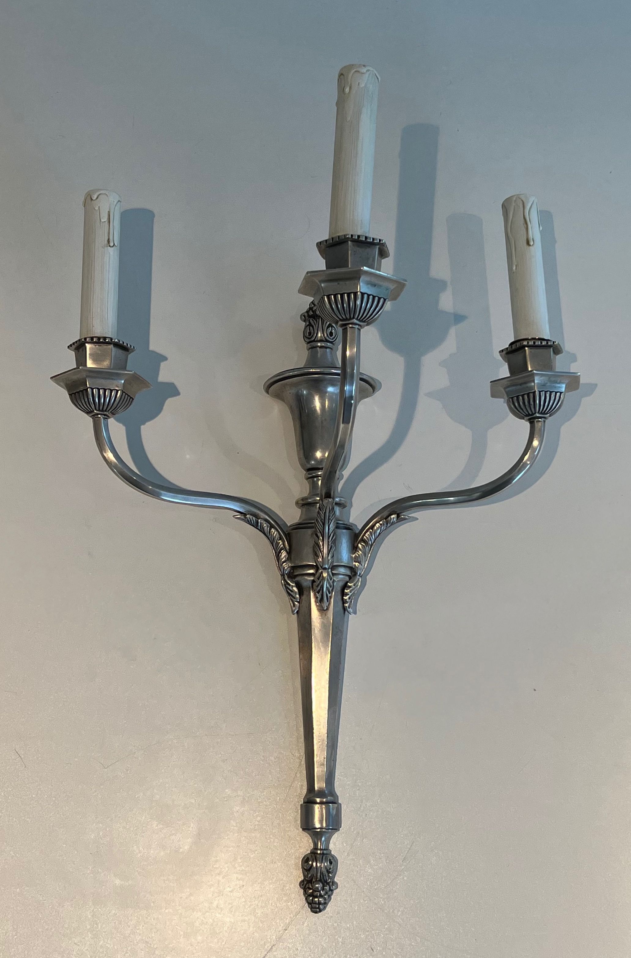 A pair of important Louis XVI style silver-plated wall sconces with three light arms.