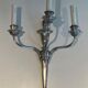 A pair of important Louis XVI style silver-plated wall sconces with three light arms.