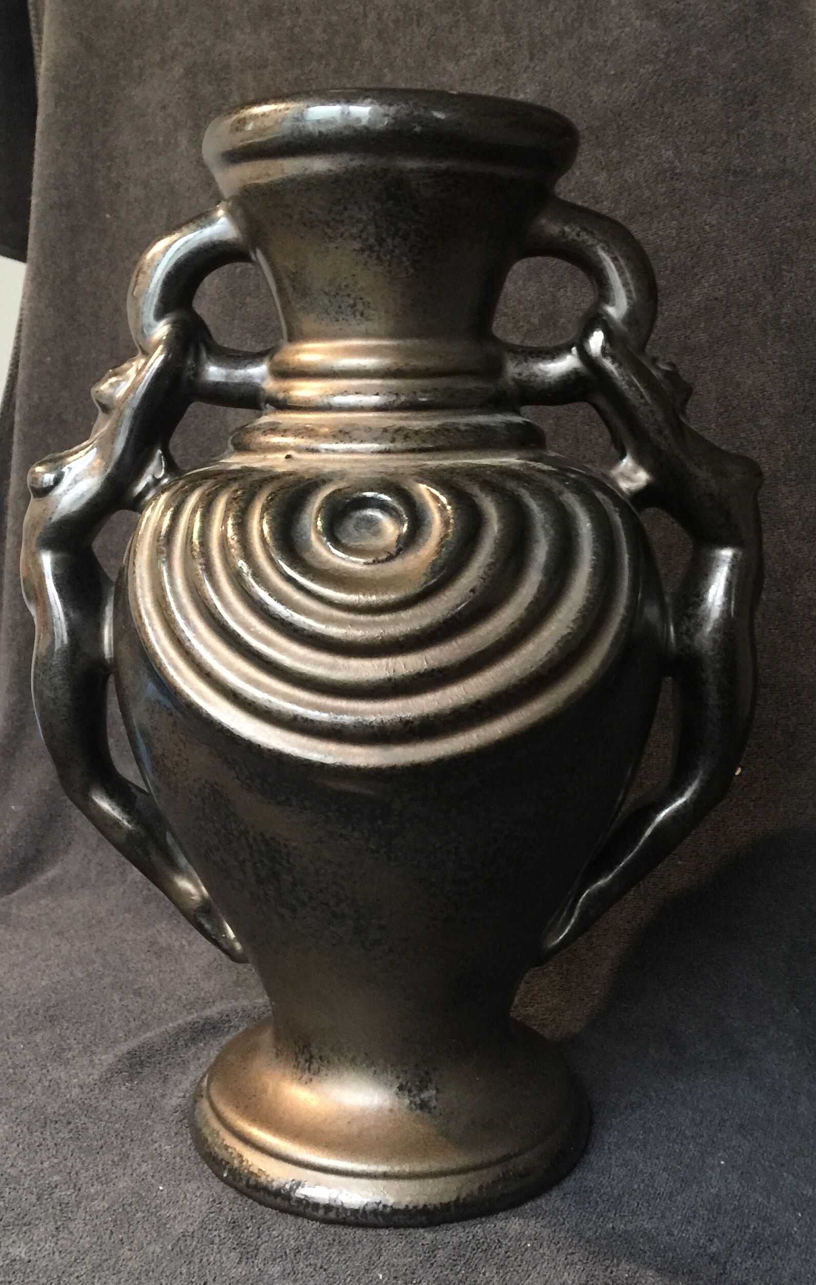 Black ceramic vase caught in naked women's bodies