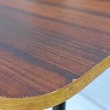 Table à manger en bois de teck et pieds en métal peint.