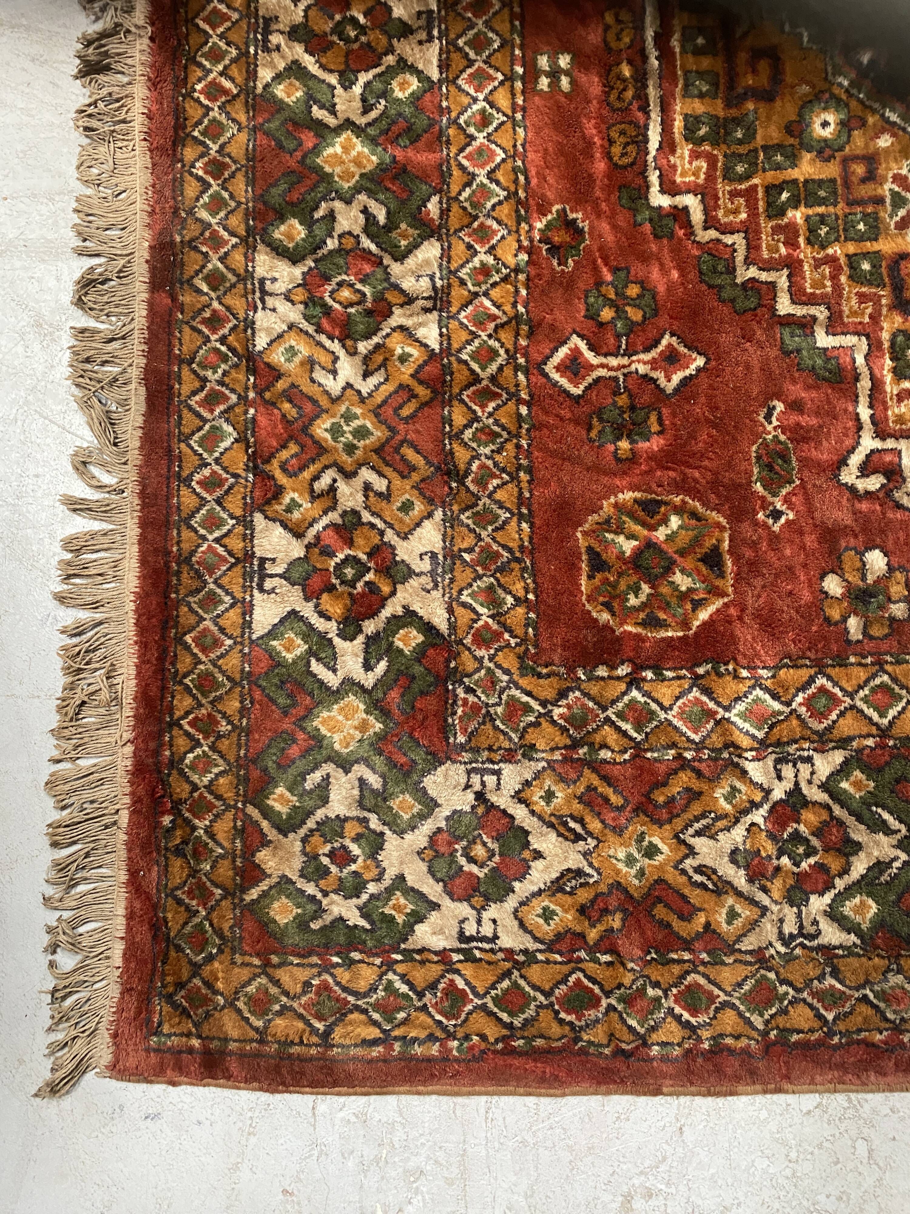 Antique wool rugs with designs on a red background, 20th century.