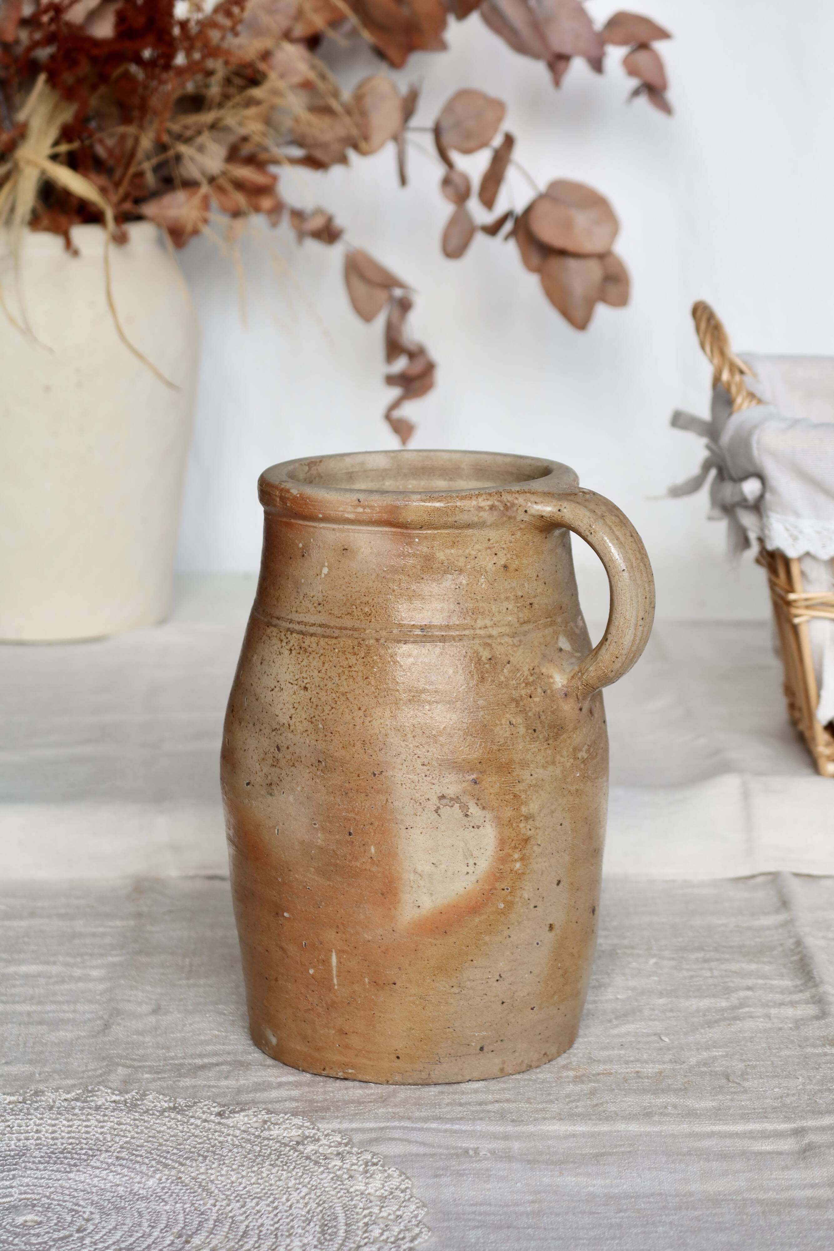 Old rustic stoneware jar with handle