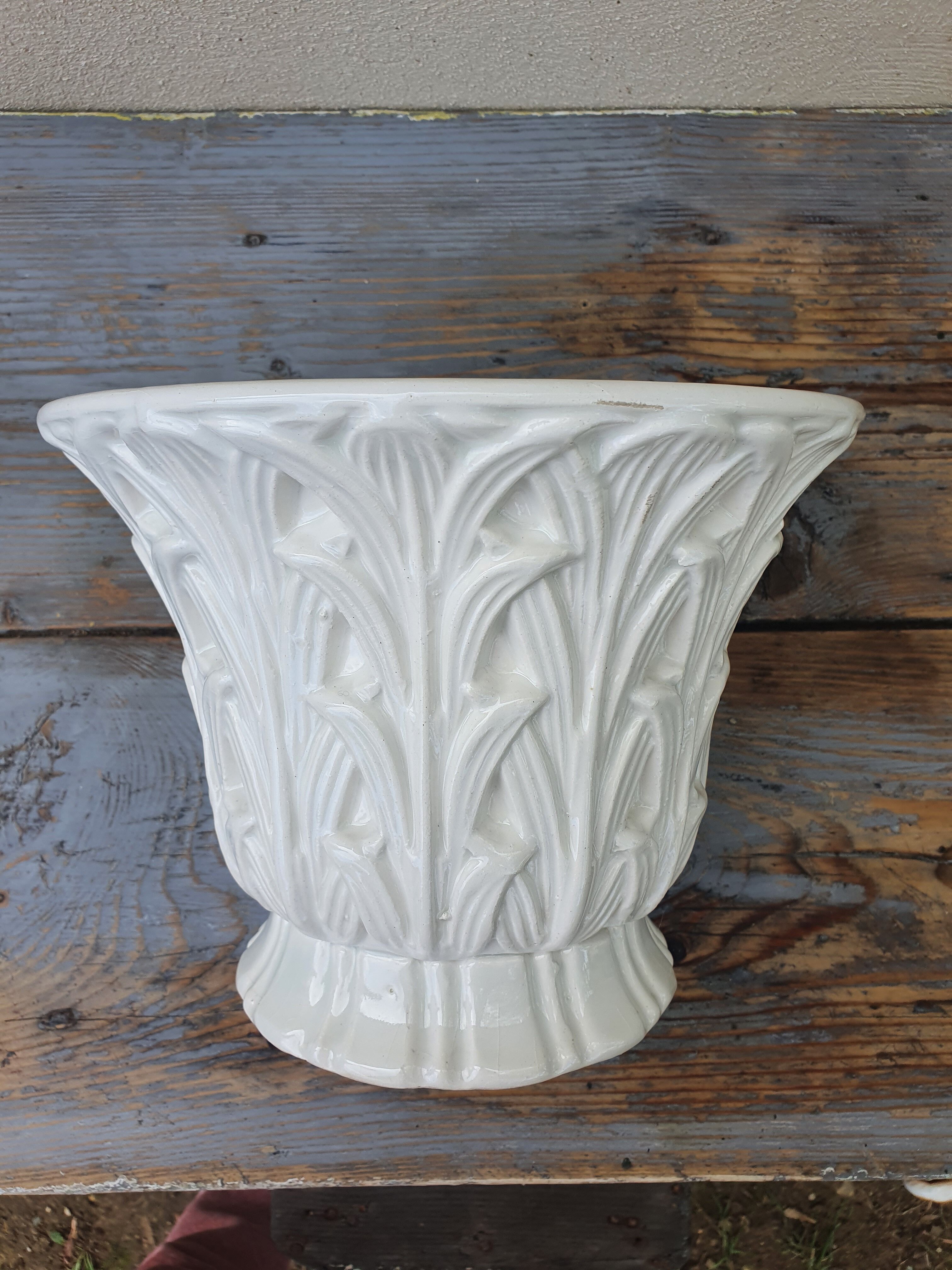 Important white earthenware pot cache with leafy decoration