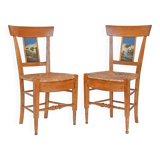 Pair of chairs with slatted backs and painted bands depicting animated landscapes.