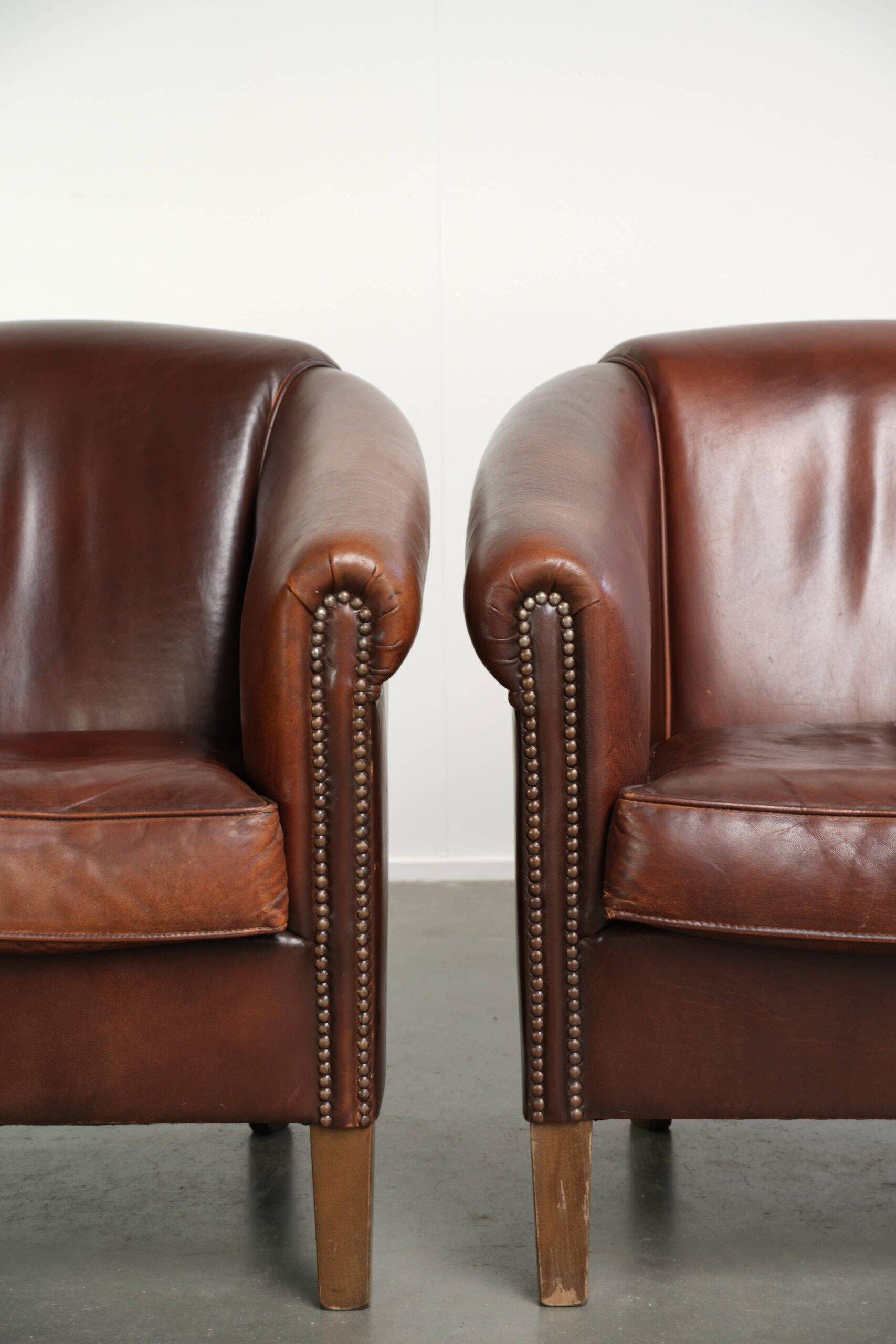 Set of 2 sheepskin club armchairs in a dark cognac colour