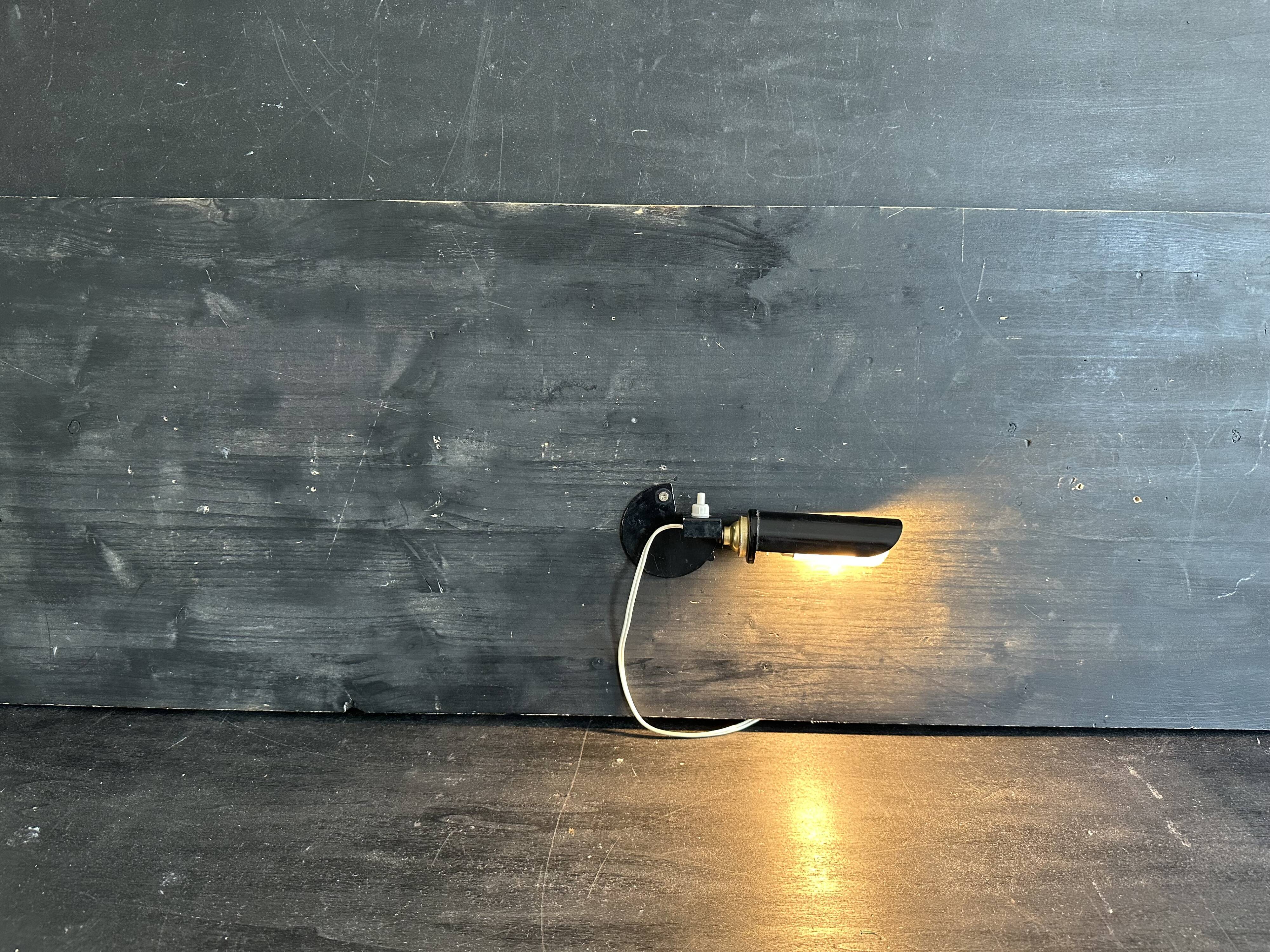 Old black metal and brass wall light, adjustable, 1930s.