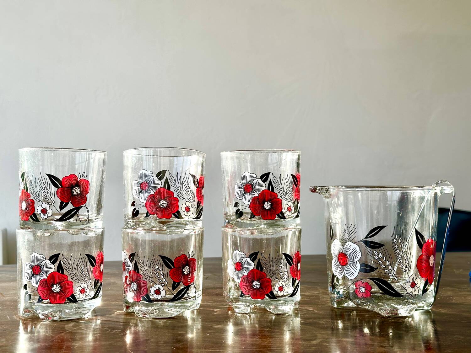 The service of 6 whiskey glasses with red flowers, with its bucket and its ice cube tongs.
