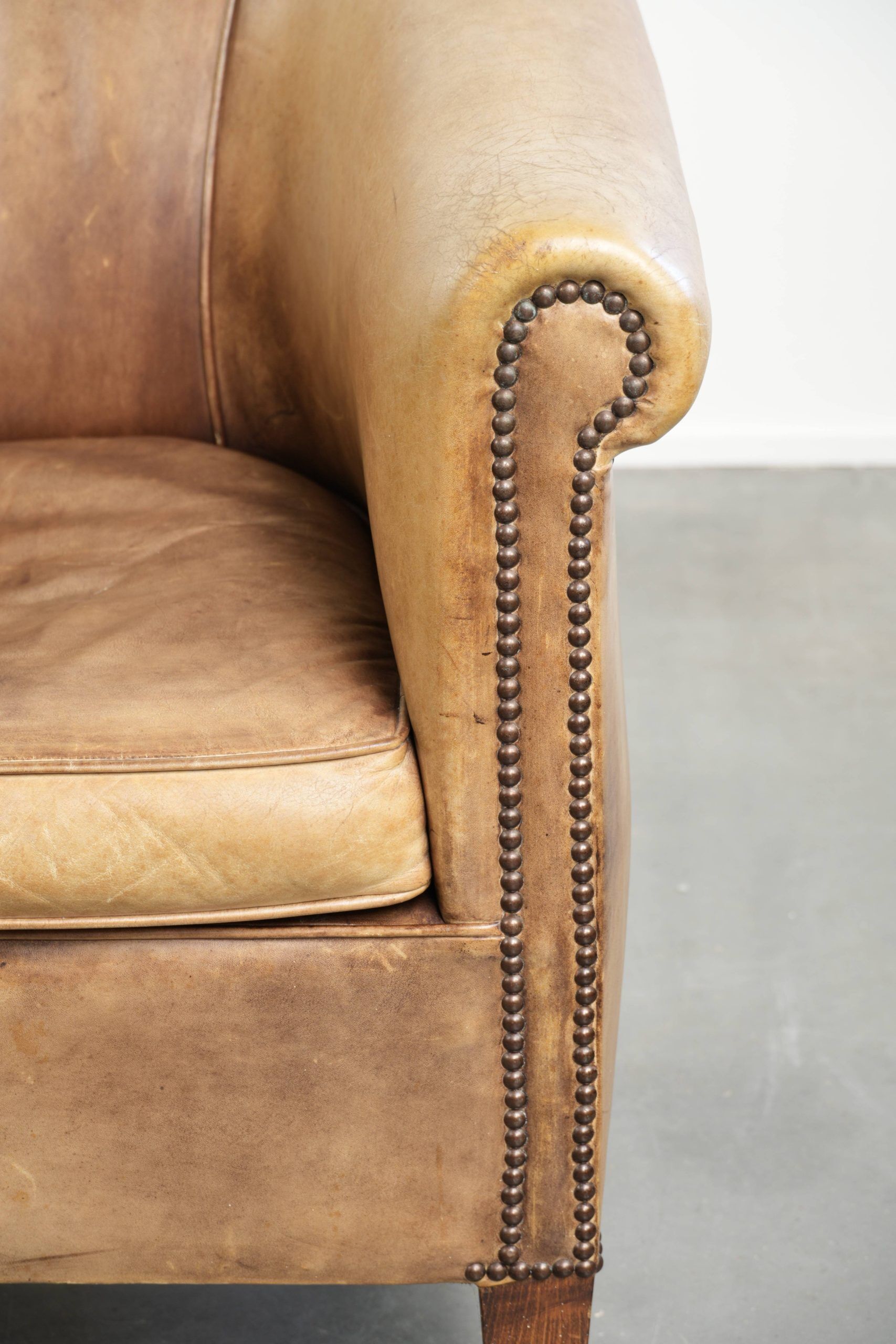 Vintage cowhide club armchair in English style in a light colour scheme