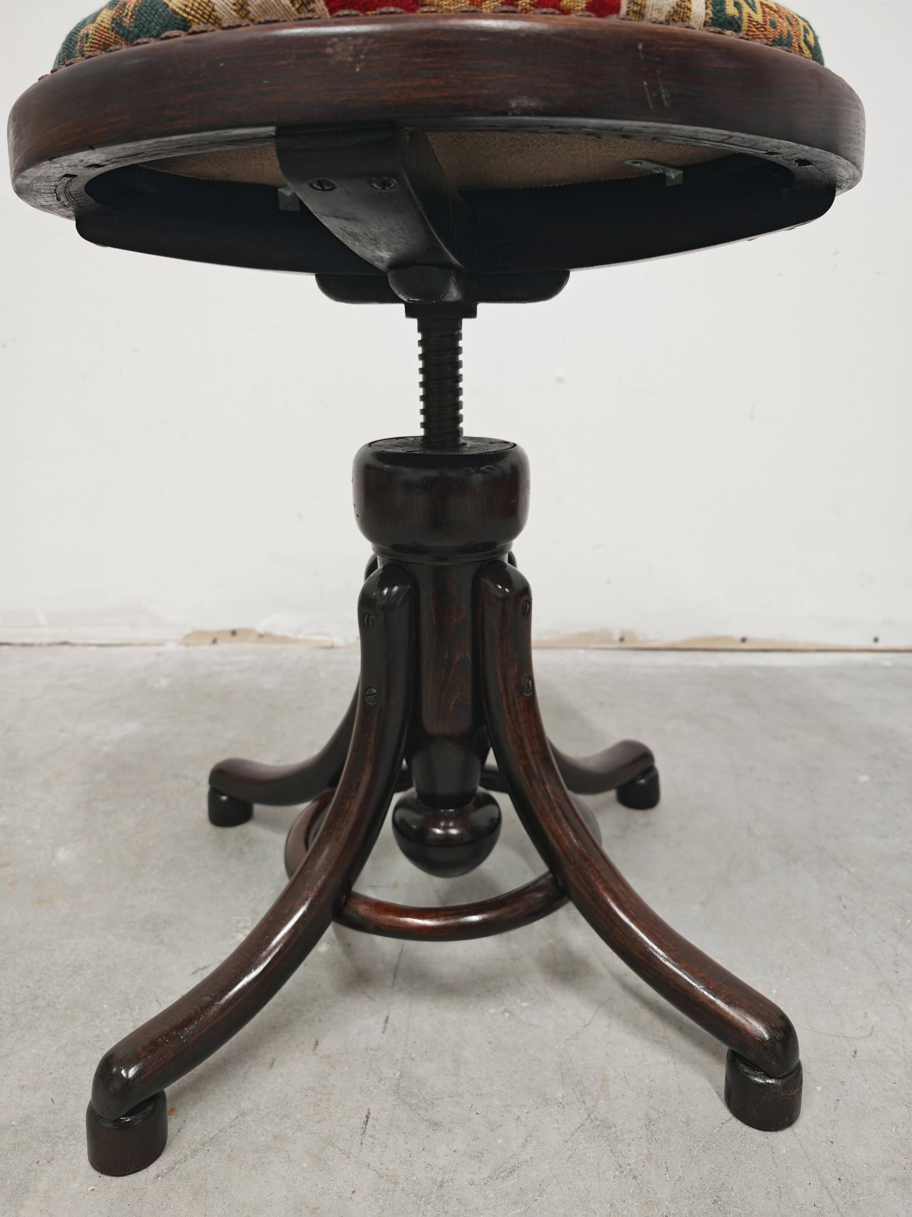 Antique curved wooden piano stool with kilim fabric from the 1910s.