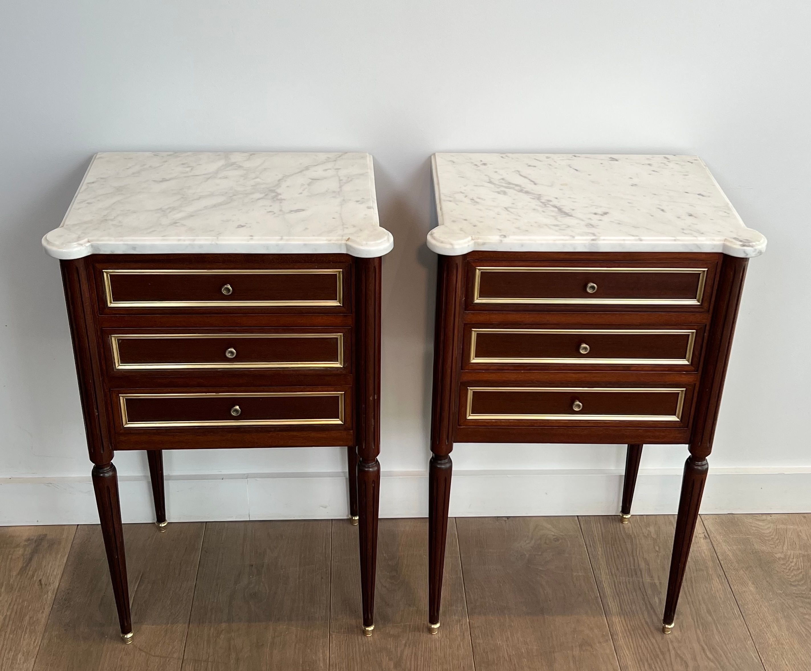 Pair of mahogany and brass side tables or bedside tables with Carrara marble tops.