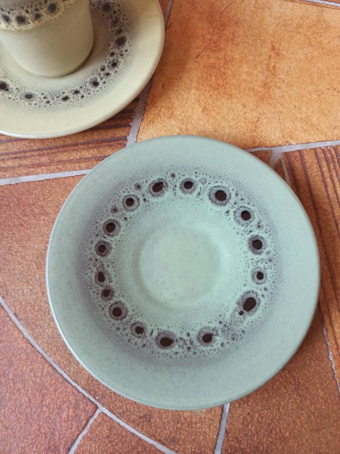 A pair of vintage glazed stoneware cups and saucers.