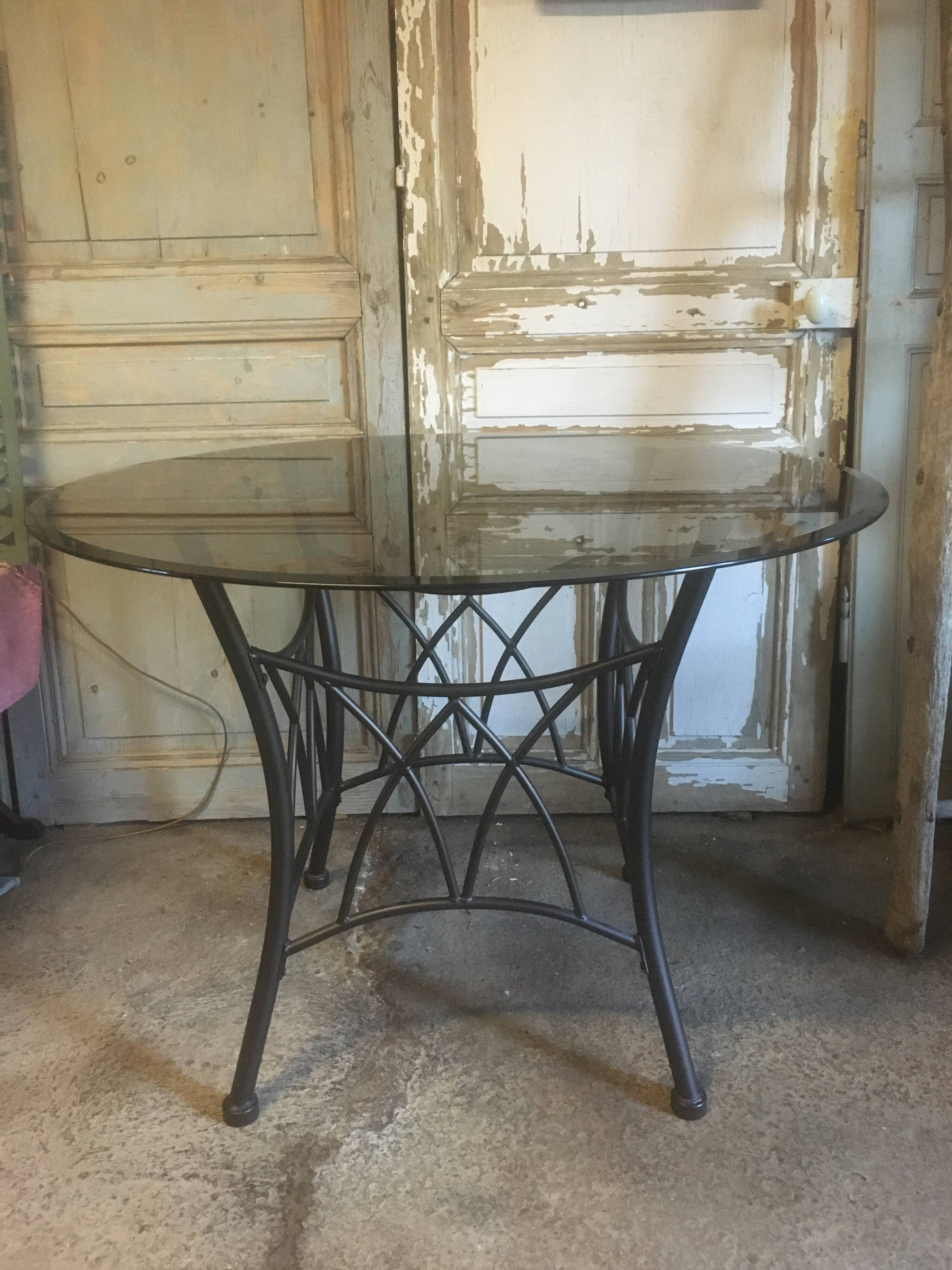 Round table with metal legs and smoked glass