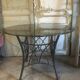 Round table with metal legs and smoked glass.