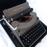 portable Remington typewriter with its suitcase and original cover