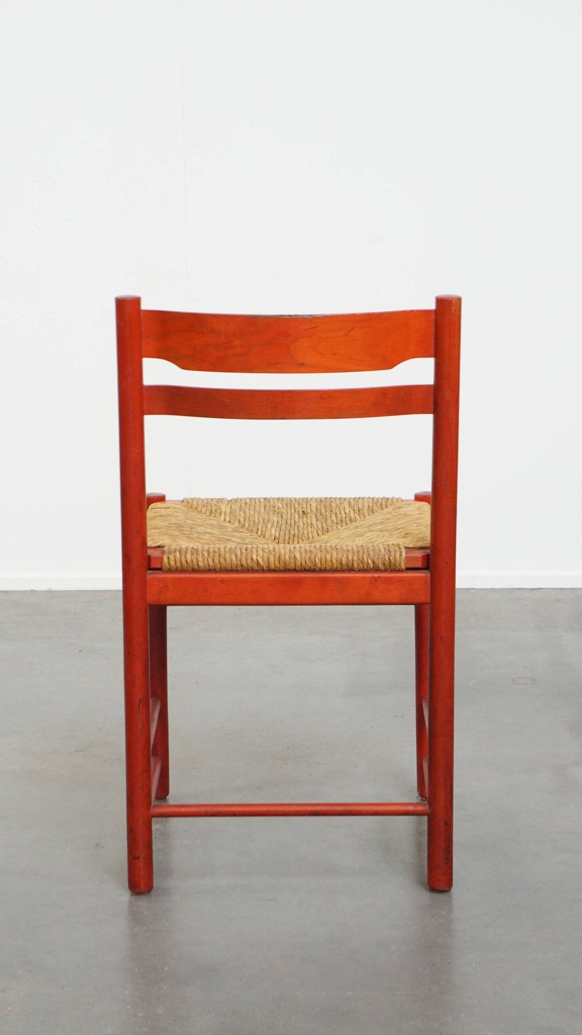 Vintage 1970s red wooden chair with a woven wicker seat