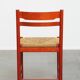Vintage 1970s red wooden chair with a woven wicker seat