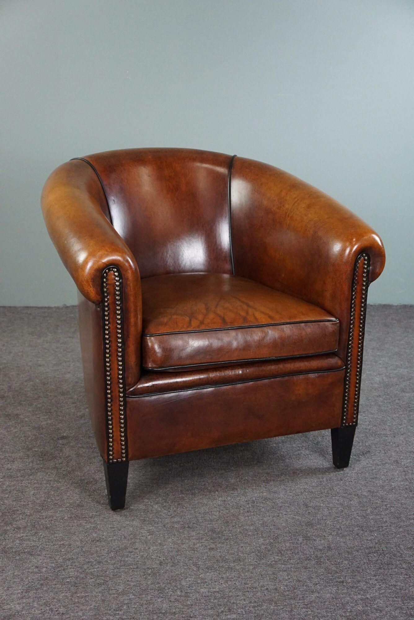 Club armchair in sheepskin with black piping
