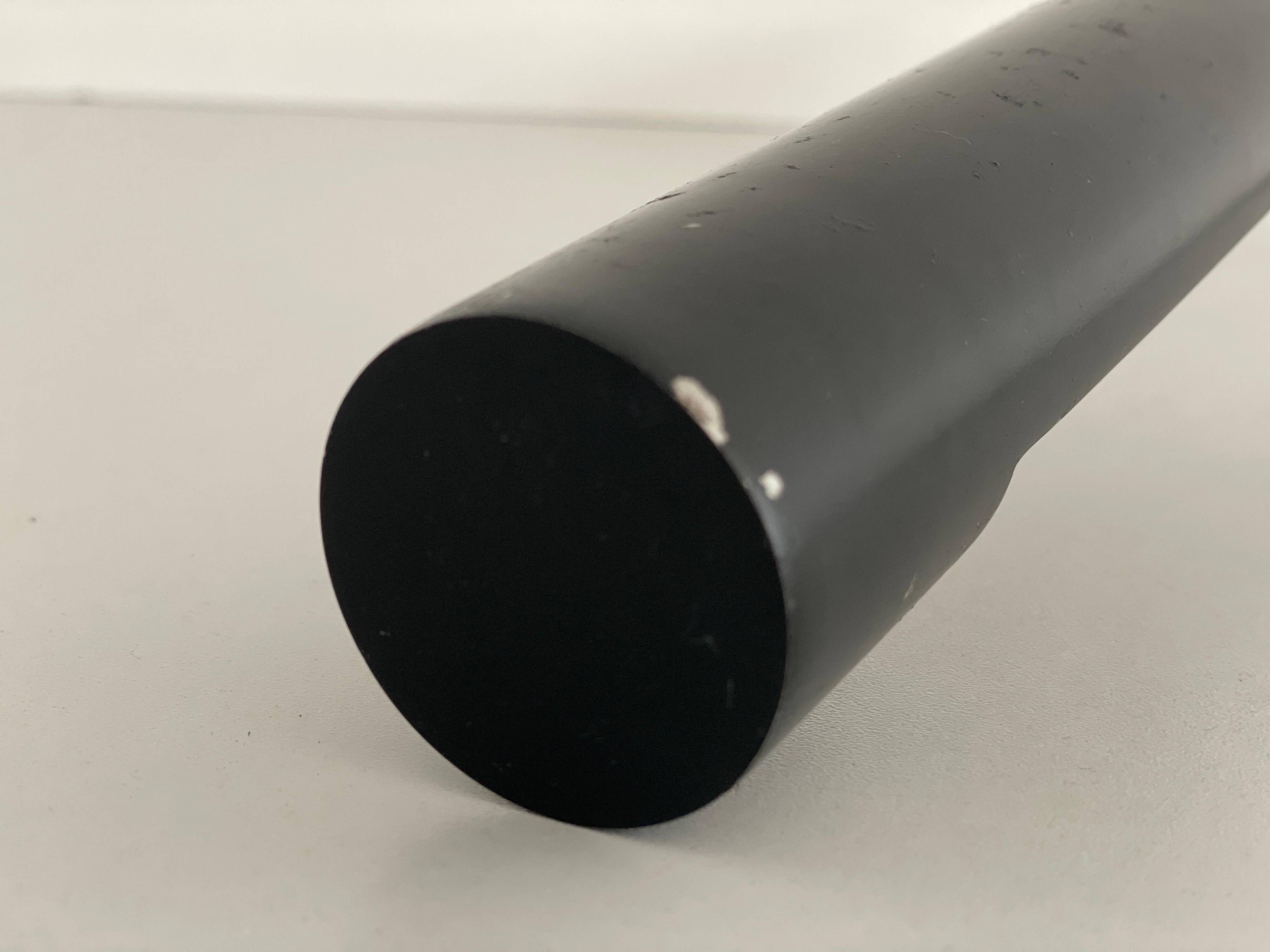 Minimalist black metal wall light with a cylindrical design, 1960s, Germany.