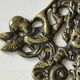 Decorative coat hook with cherubs/putti in aged brass.