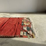 Small wool rug, predominantly red with geometric patterns