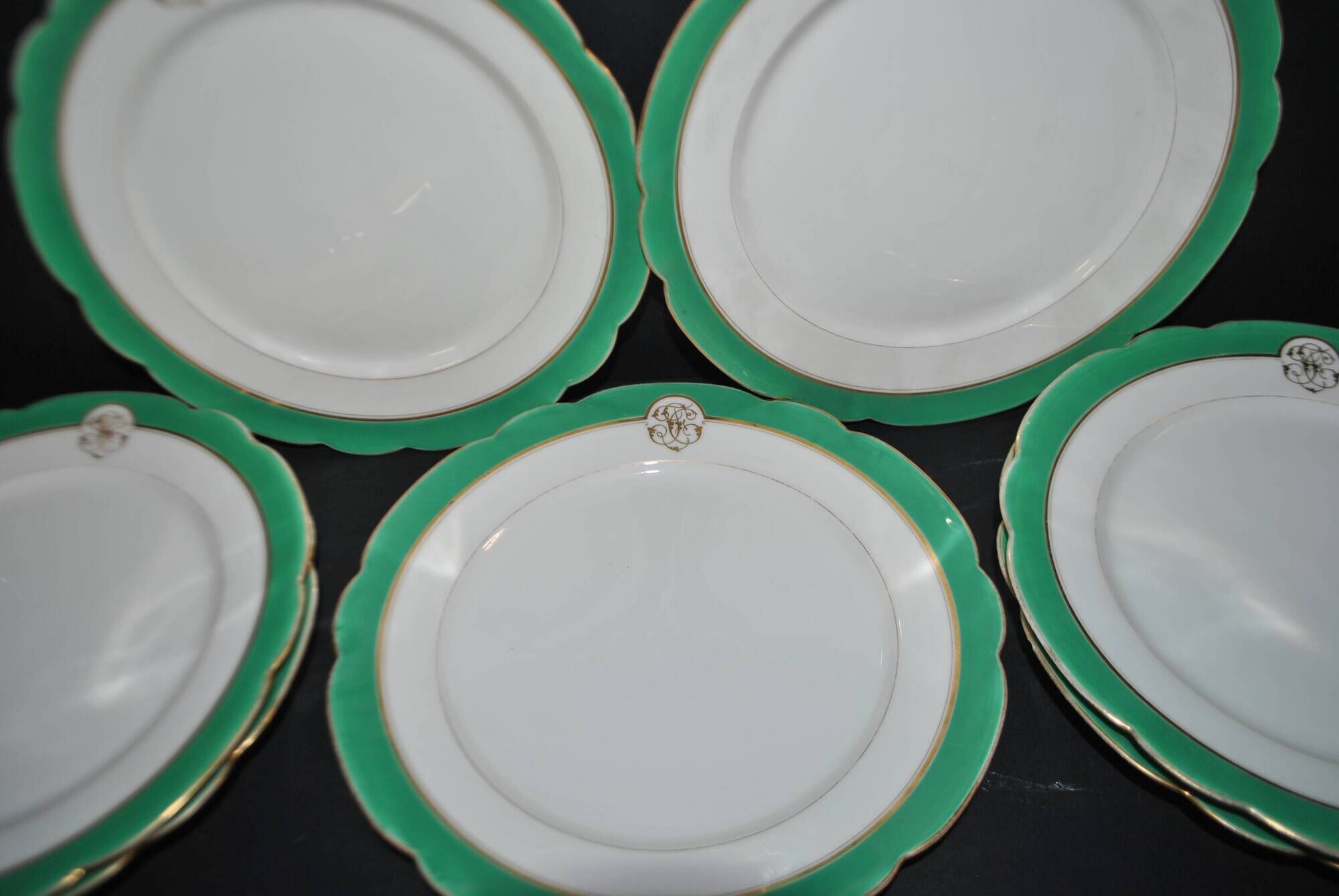 Paris porcelain set of 12 flat plates with green border and gold monogram JC.