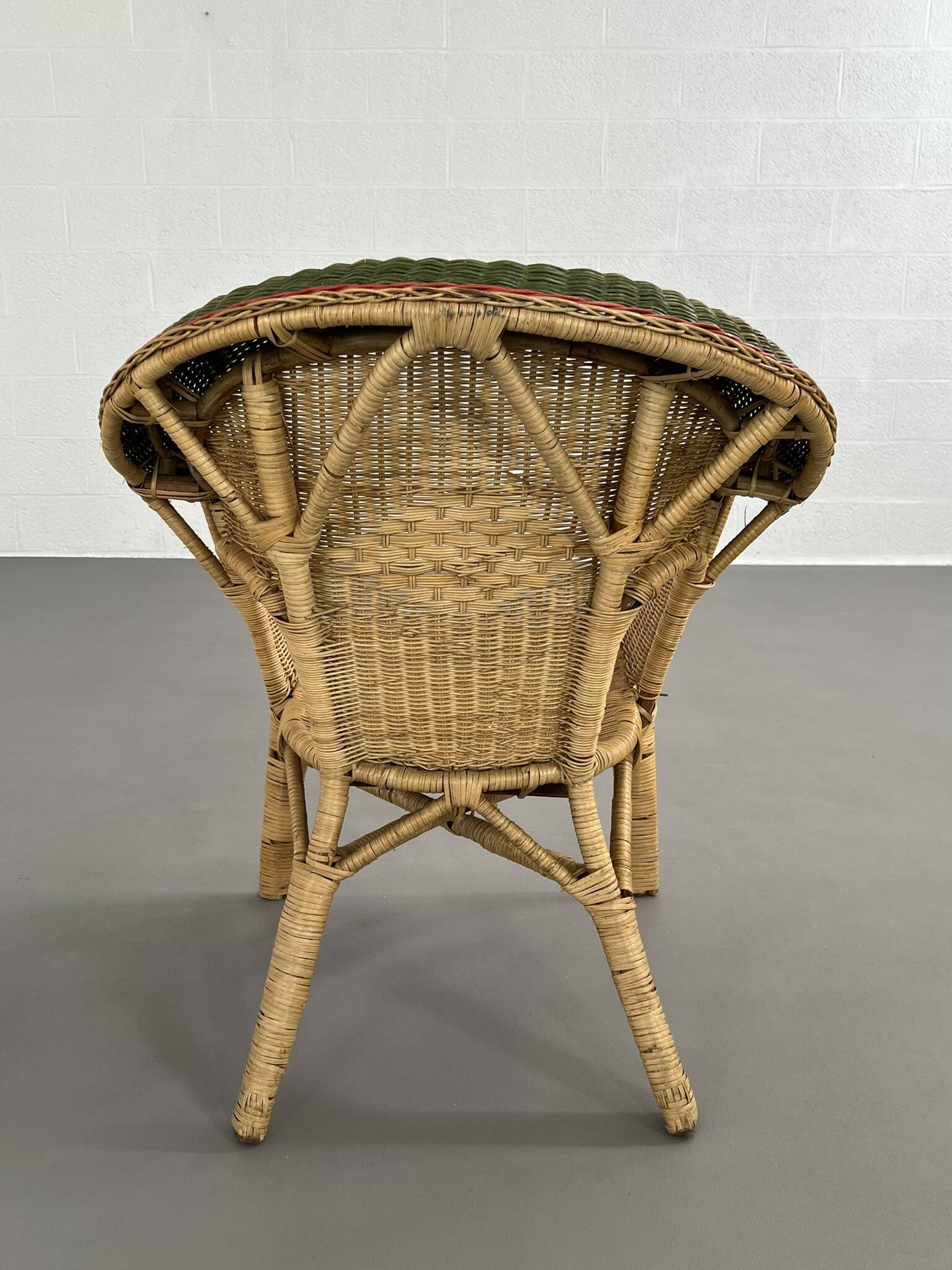 Cabriolet style armchair in rattan, wicker and green and red edging