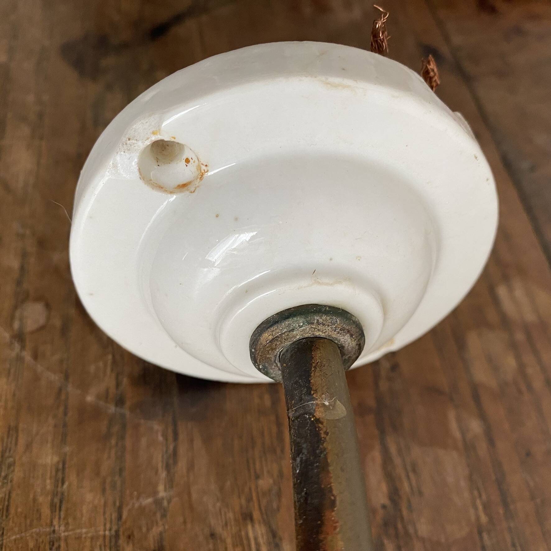 Antique swan neck wall light in brass and porcelain with a glass shade.