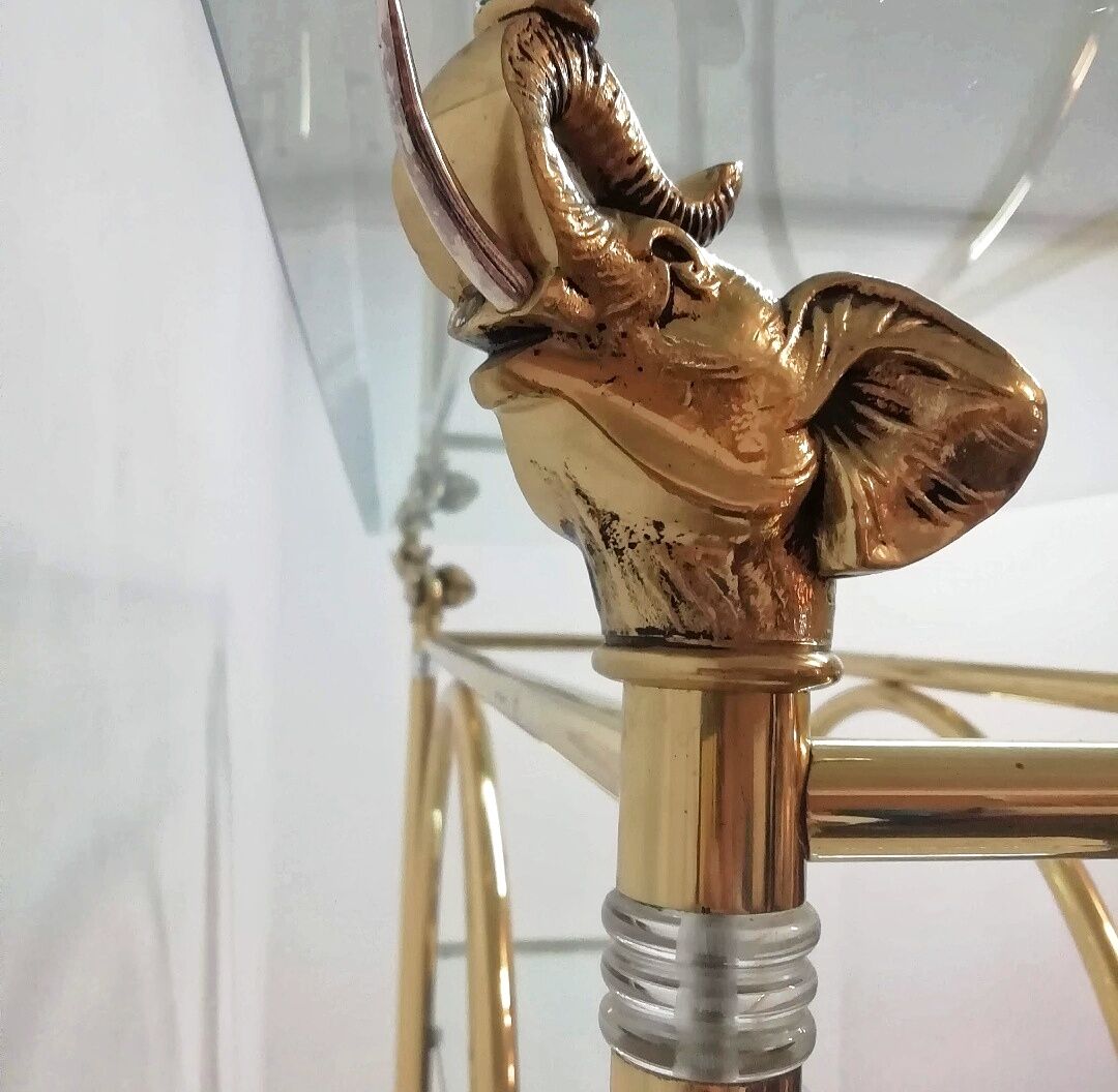 Hollywood Regency brass and glass shelf with elephant heads from the 1970s
