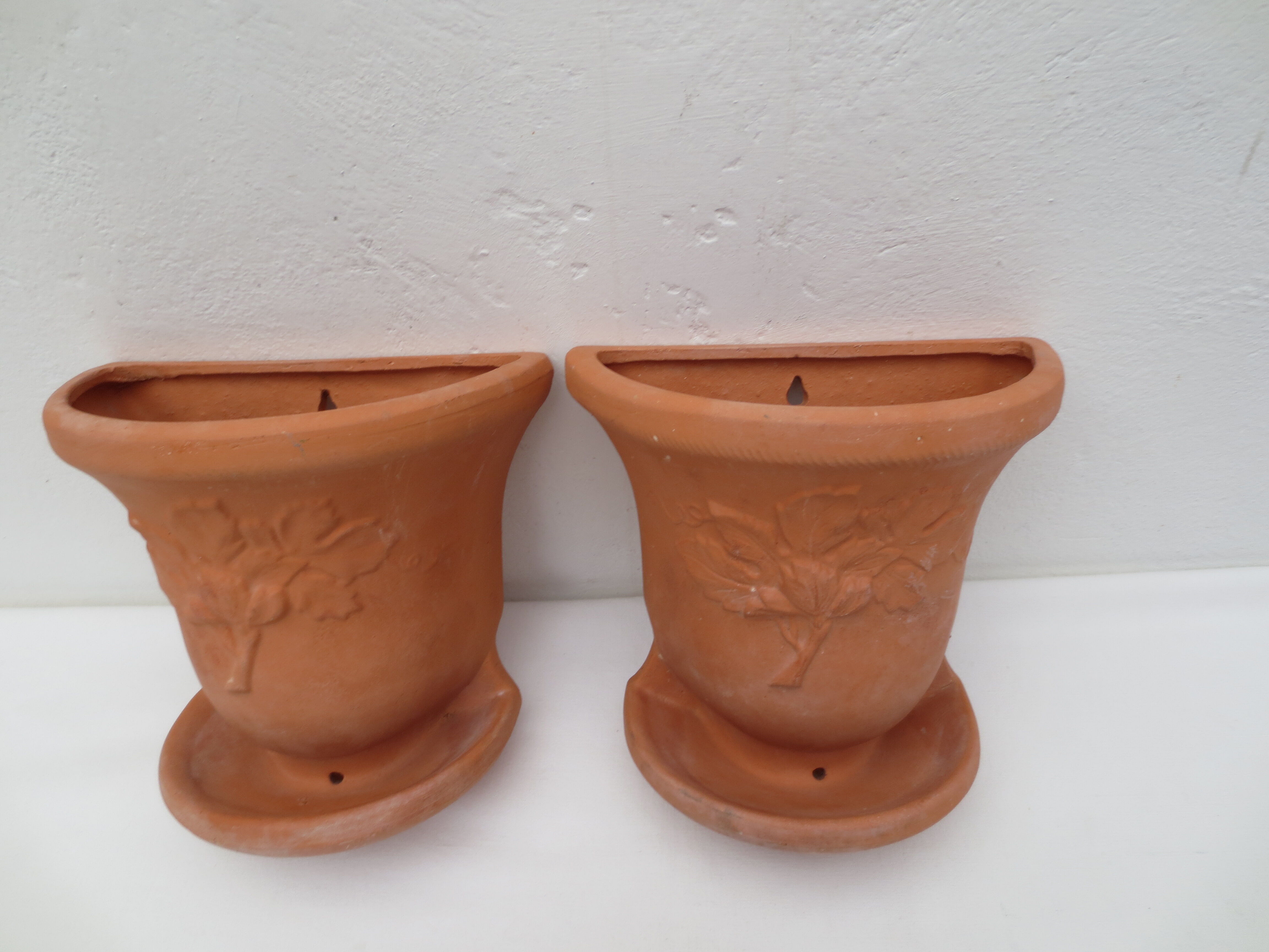 Duo of decorated terracotta wall flowerpots