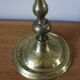 Brass candle holder with flowers and round shape.
