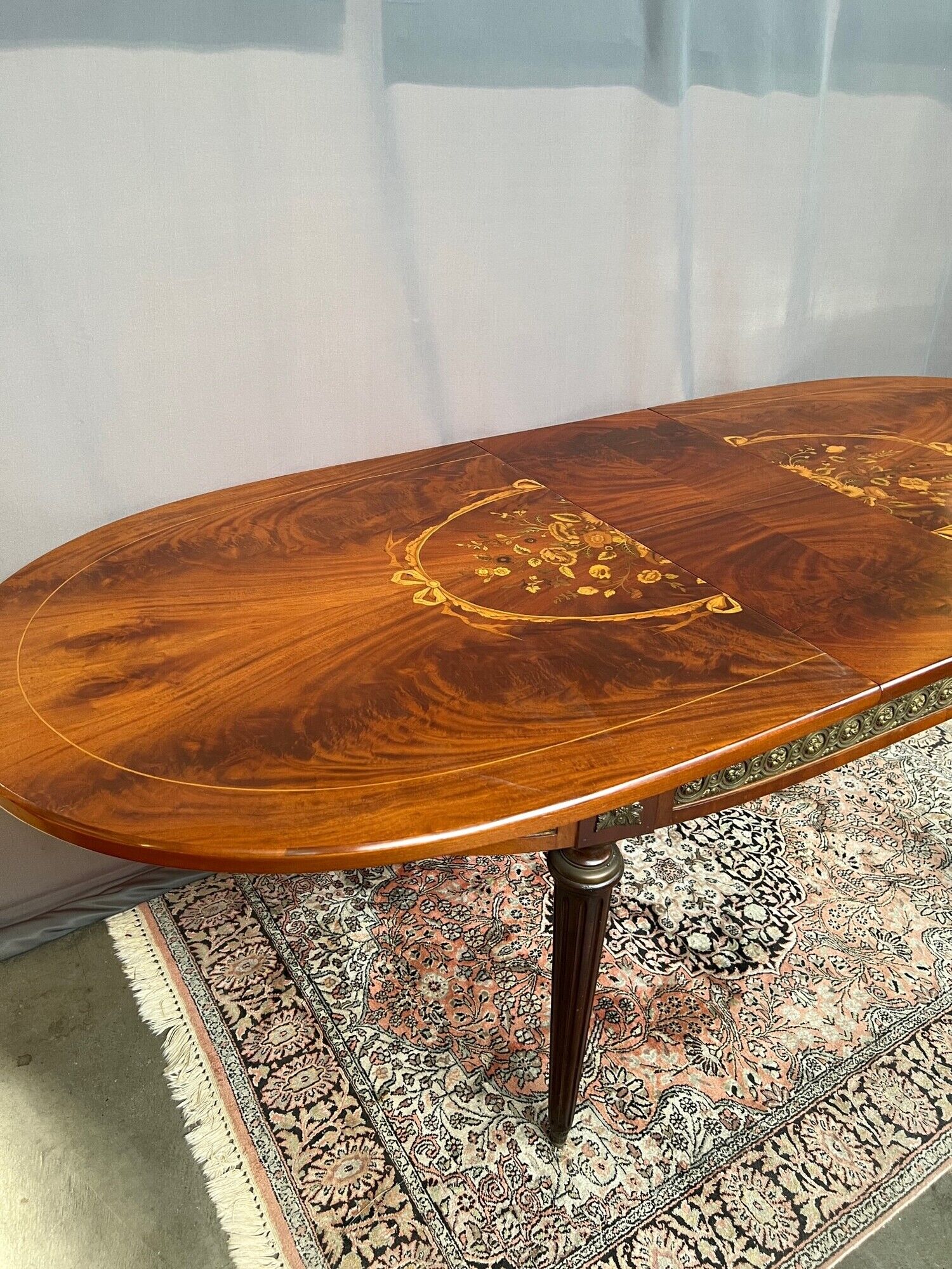 Louis XVI style oval dining table with rosewood marquetry extension mounted in bronze