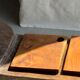 Small rectangular teak monoxyle cutting board with a circular handle.