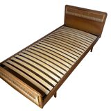 Vintage single bed made of rattan from the 1970s with a mattress.