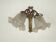 Double wall light in bronze in French Rococo style with white glass shades featuring patterns.
