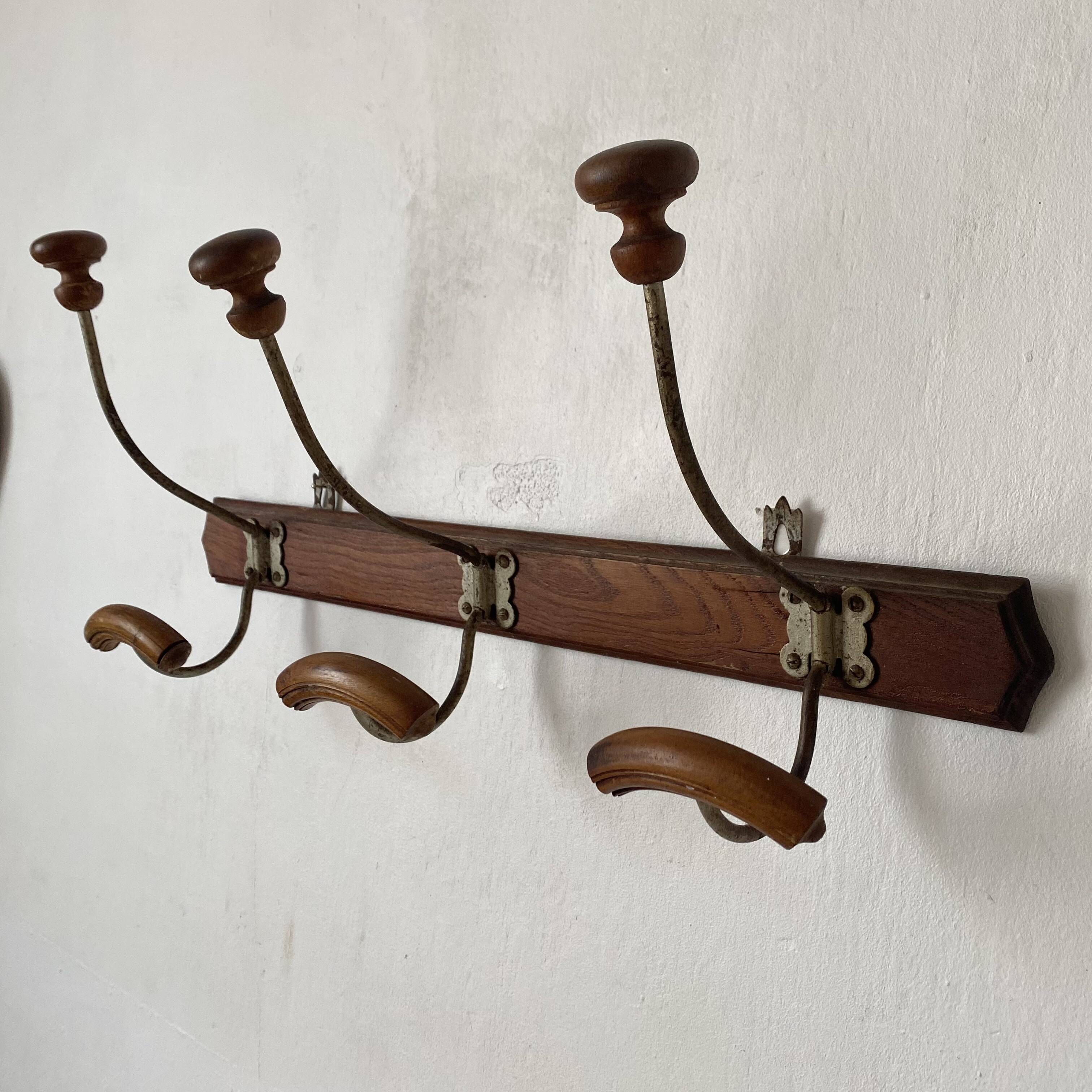 Antique wall-mounted coat rack in wood and metal