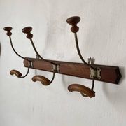 Old wooden and metal wall-mounted coat rack.