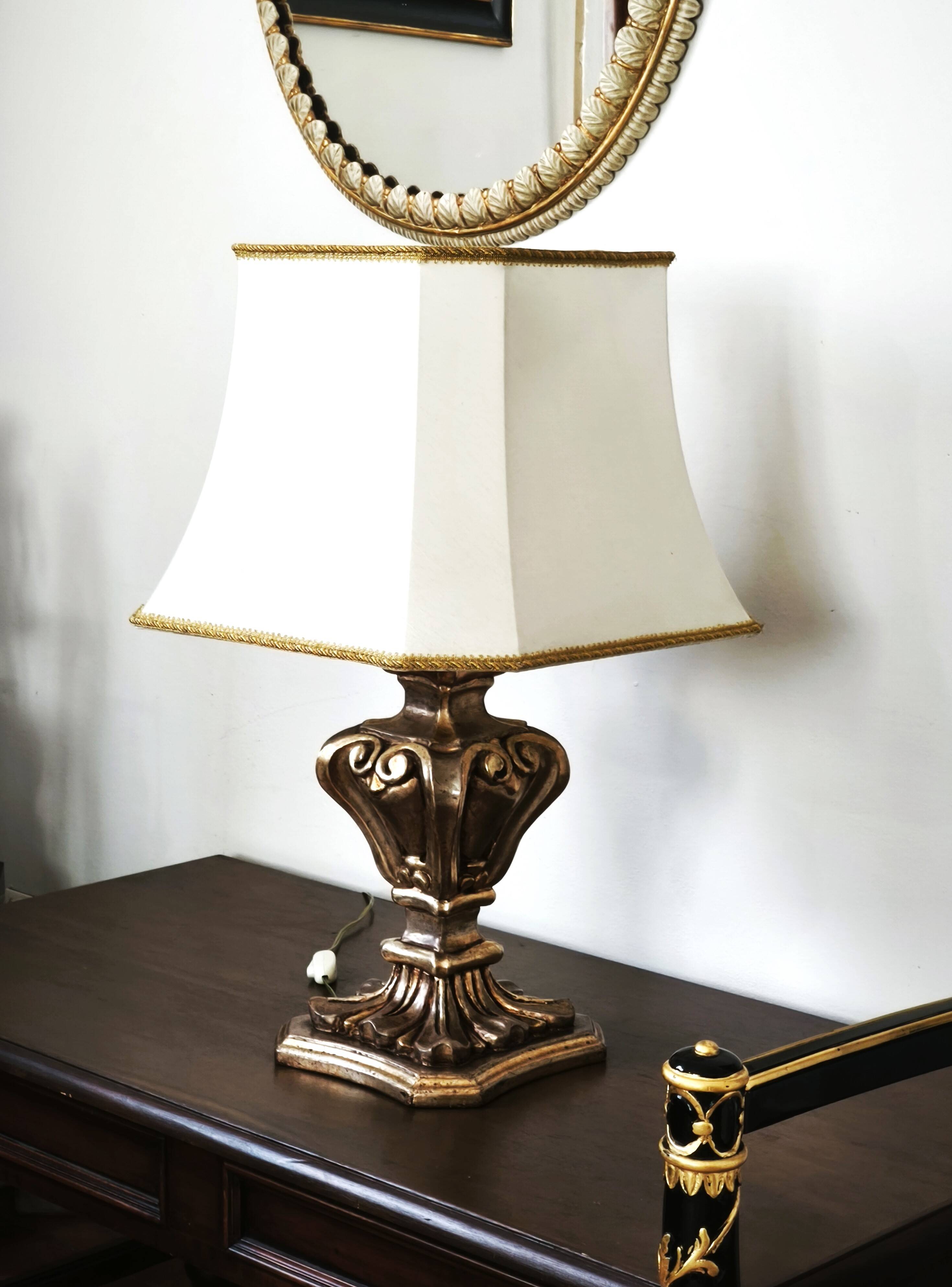 Florentine lamp in carved wood, gold leaf, silk shade.