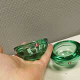 A set of iitalla candle holders in green transparent glass.