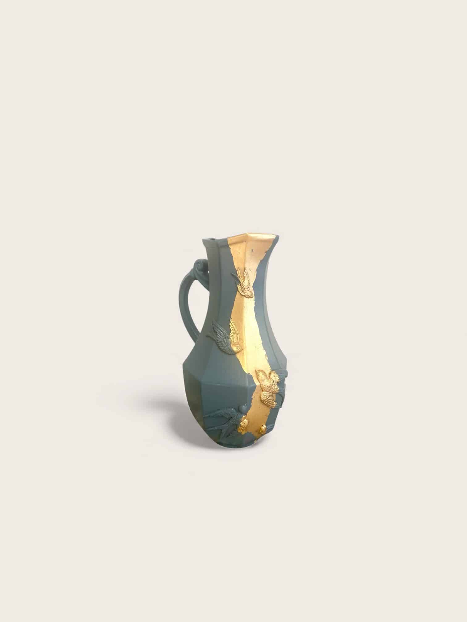 Large decorative blue-grey pitcher with swallow mouldings and gold leaf.