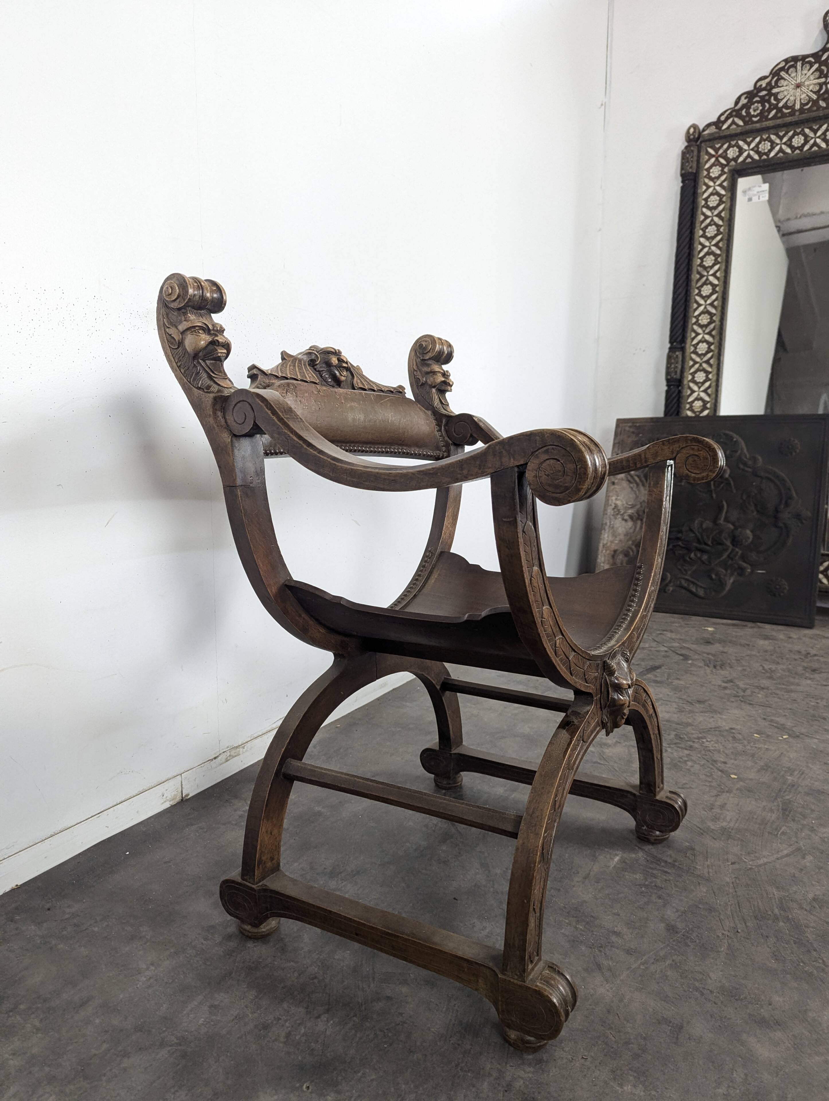 Curule chair Dagobert in carved walnut with lion heads.