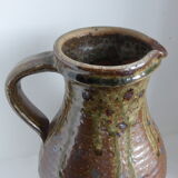 Old pitcher in brown sandstone with green drippings