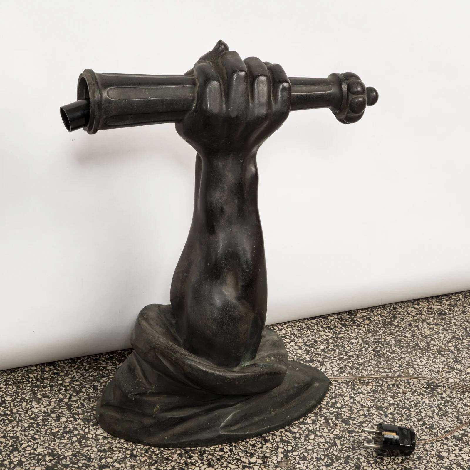 Wall lamp in iron shaped like an arm.